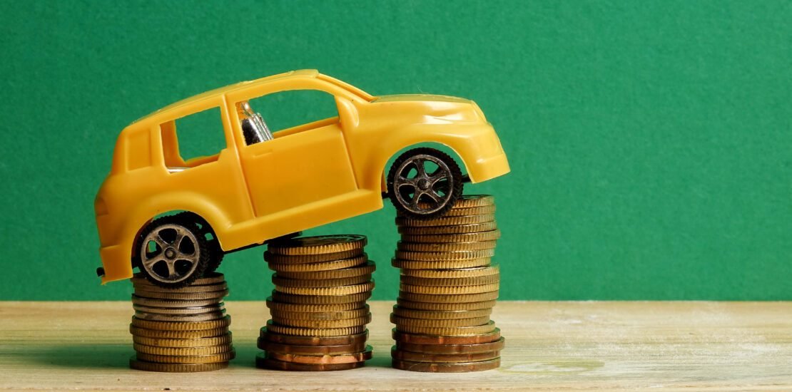 close up toy car stack coins against green wall 1 scaled